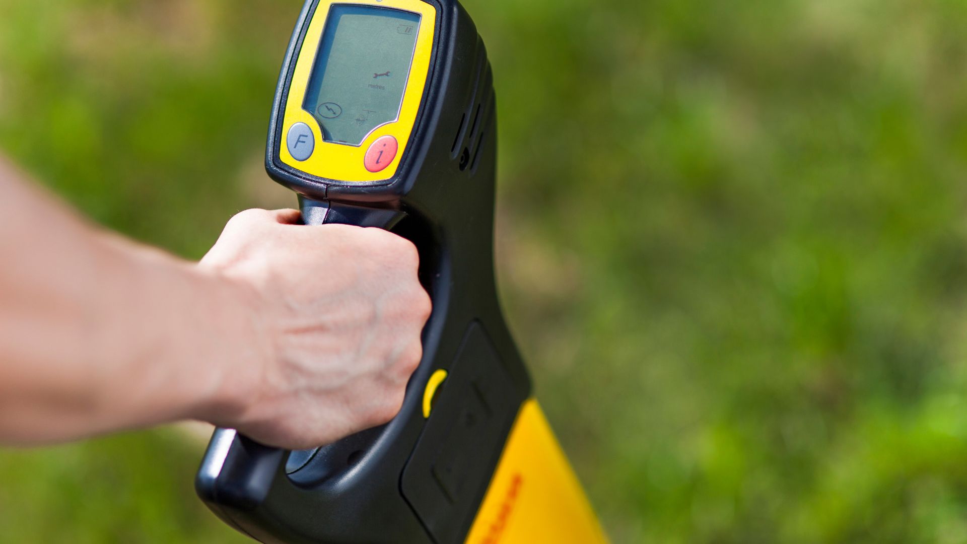 A person holding a yellow and black device in their hand